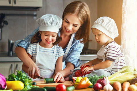 mamá feliz con sus niños cocinando comida saludable