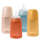 un biberón naranja con marcas de medidas y tetina blanca